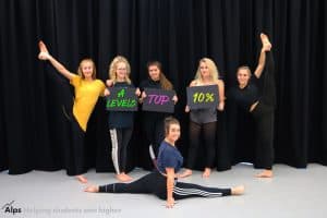 Performing Arts students holding up 3 boards reading A Levels Top 10%