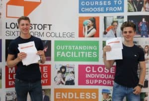 Two students holding up their exam results