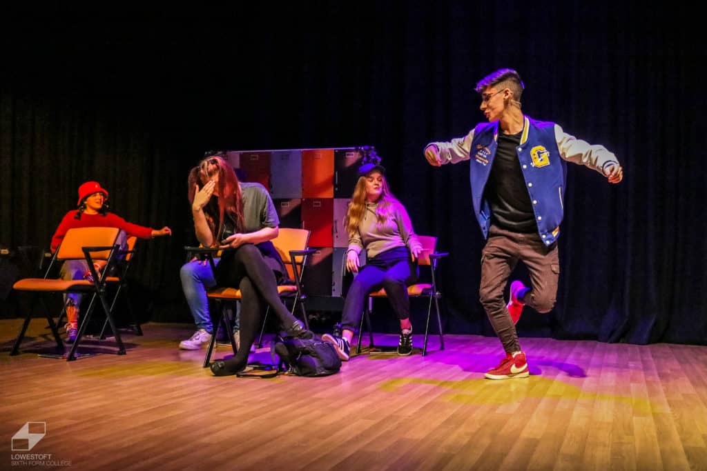1 performer dancing and 3 performers seated